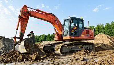 Excavator clearing land at a construction site